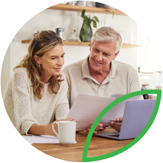 Mature couple on laptop in kitchen.