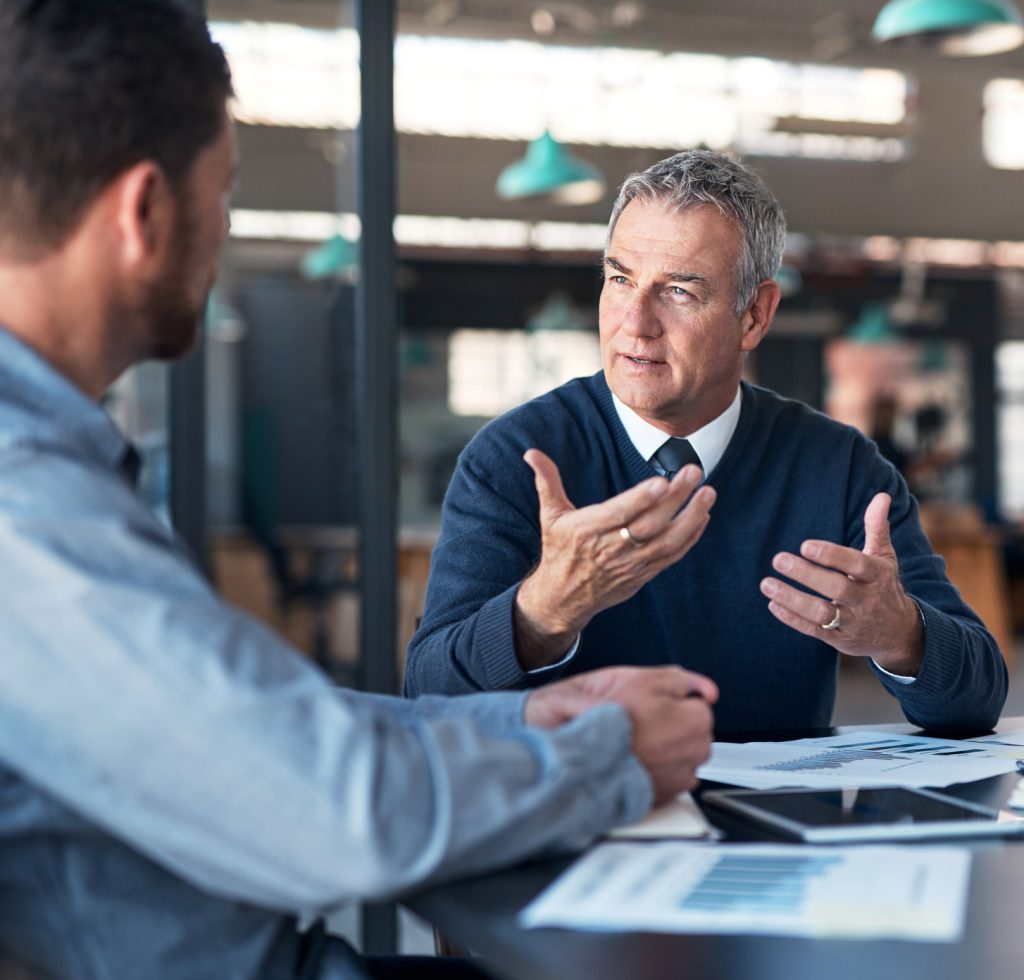 Shot of a mature businessman having a discussion with a colleague in an office